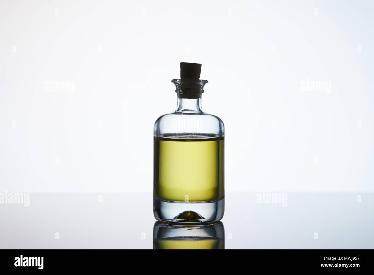 Flacone chiuso di olio aromatico di massaggio su bianco Foto Stock