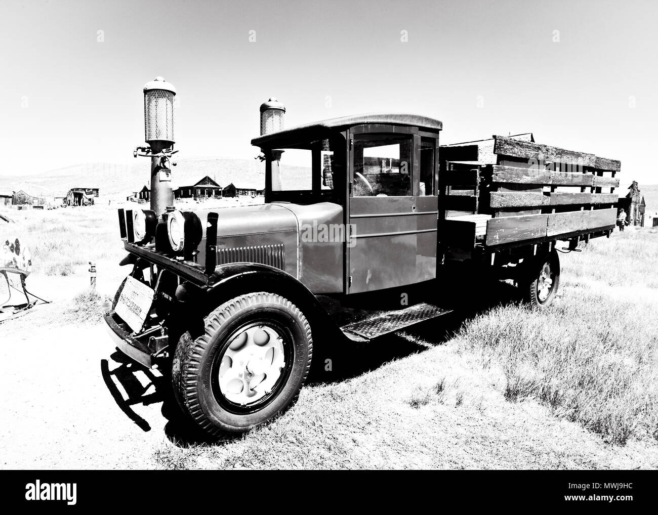Immagine in bianco e nero di legno incorniciato 1927 ford graham pick truck abbandonato nella città fantasma di Bodie, con case derelict, mono contea, California Foto Stock