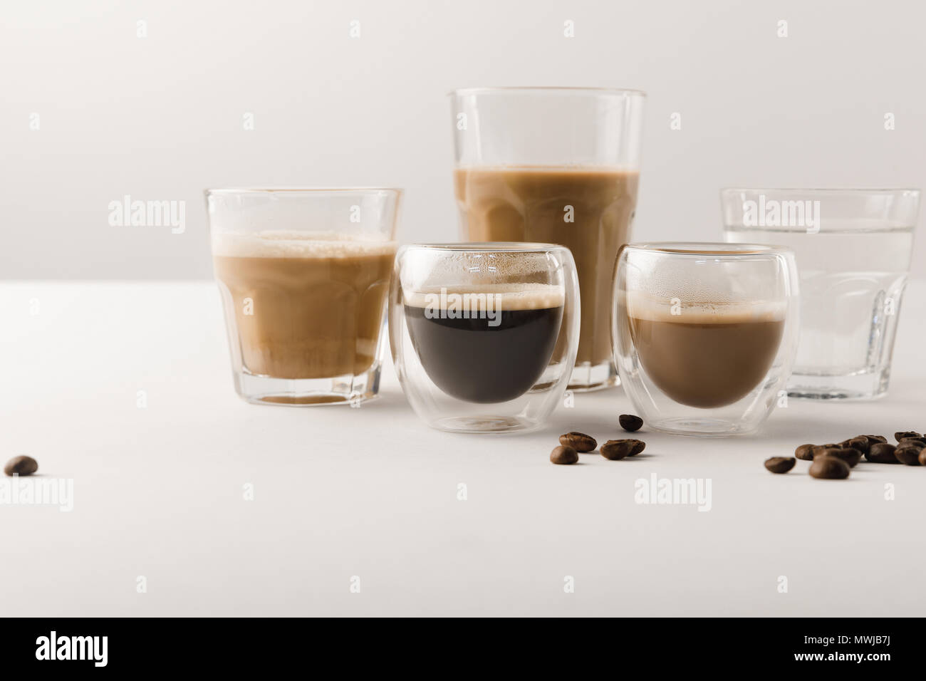 Serie di tazze con assortimento di bevande di caffè su sfondo bianco Foto Stock