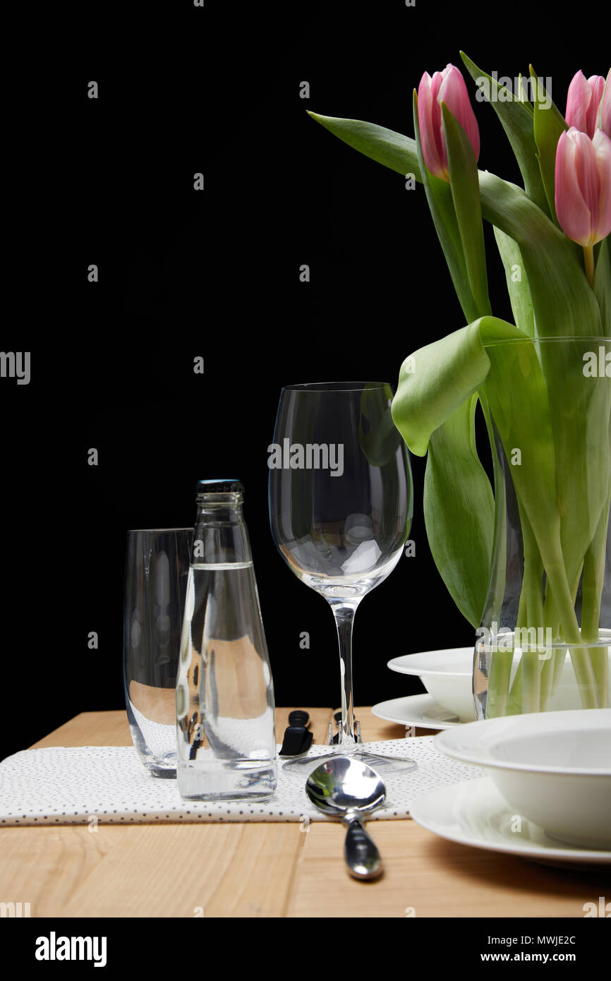 Vaso con bouquet di fiori sul tavolo con stoviglie di festa Foto Stock