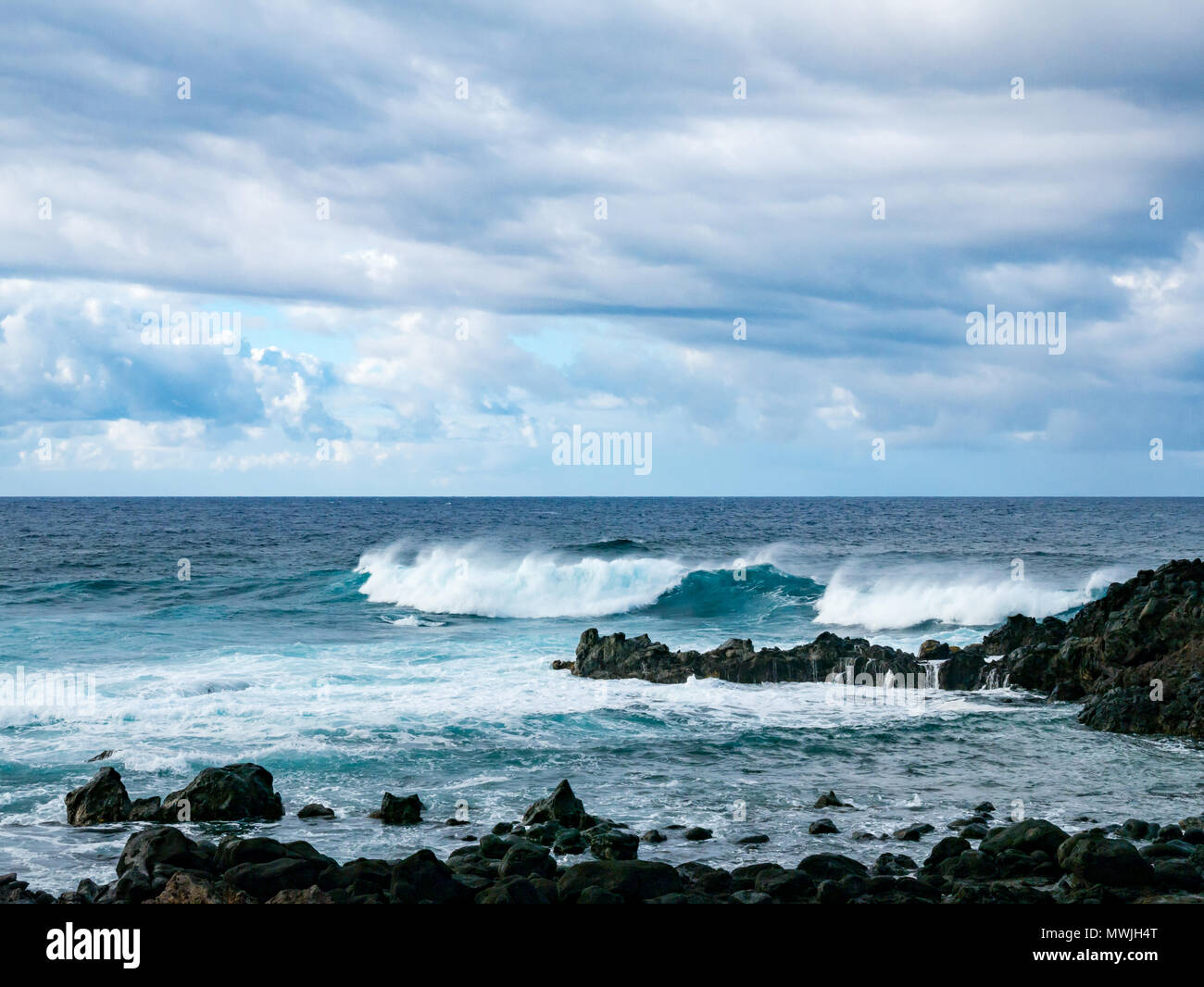 Oceano Pacifico di onde che si infrangono sulla spiaggia rocciosa, costa sud dell'isola di pasqua, Rapa Nui, Cile Foto Stock