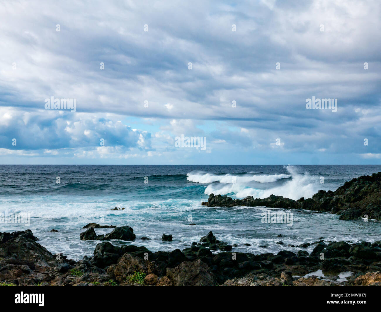 Oceano Pacifico di onde che si infrangono sulla spiaggia rocciosa, costa sud dell'isola di pasqua, Rapa Nui, Cile Foto Stock