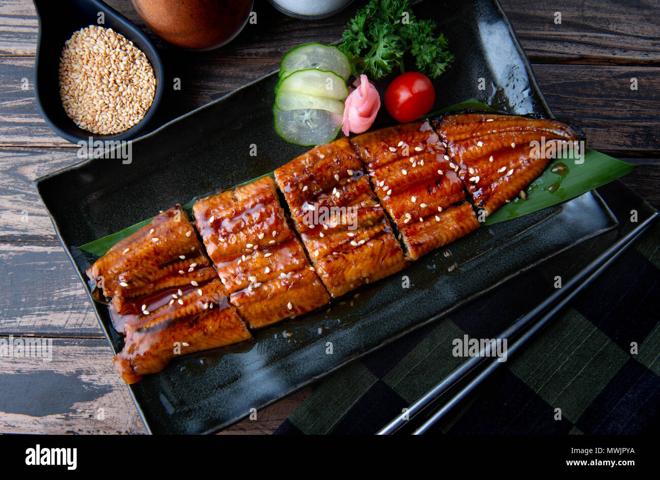 Tagliare il giapponese anguilla alla brace o Unagi ibaraki impostato su piastra in stile Giapponese con illuminazione studio Foto Stock