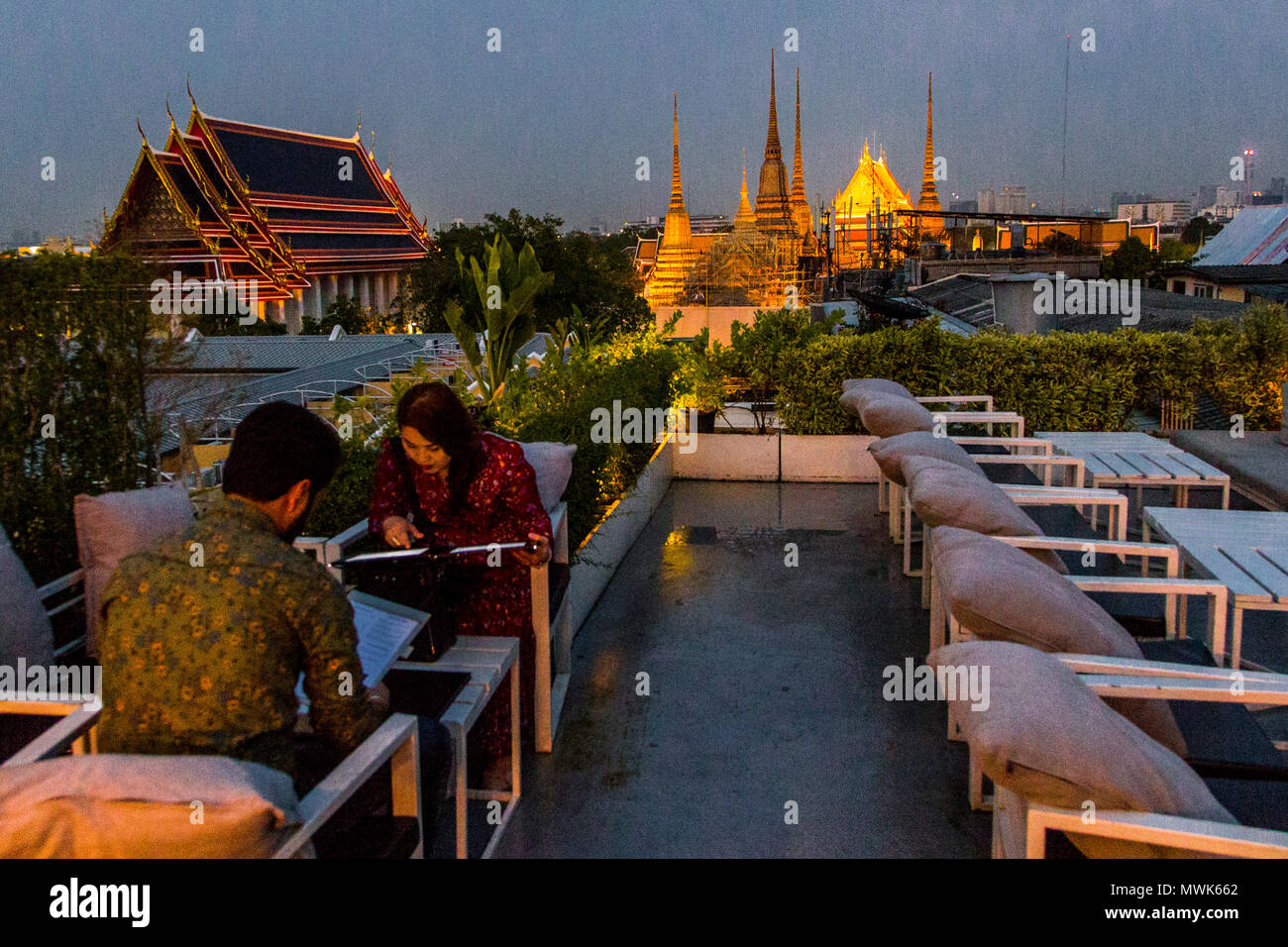 Un paio prima di cena a Bangkok durante il tramonto con i templi buddisti dietro di loro Foto Stock