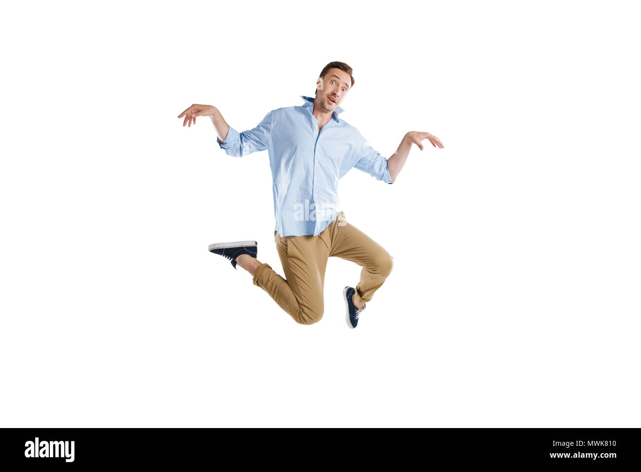 Giovane uomo informale jumping con espressione divertente isolato su bianco Foto Stock