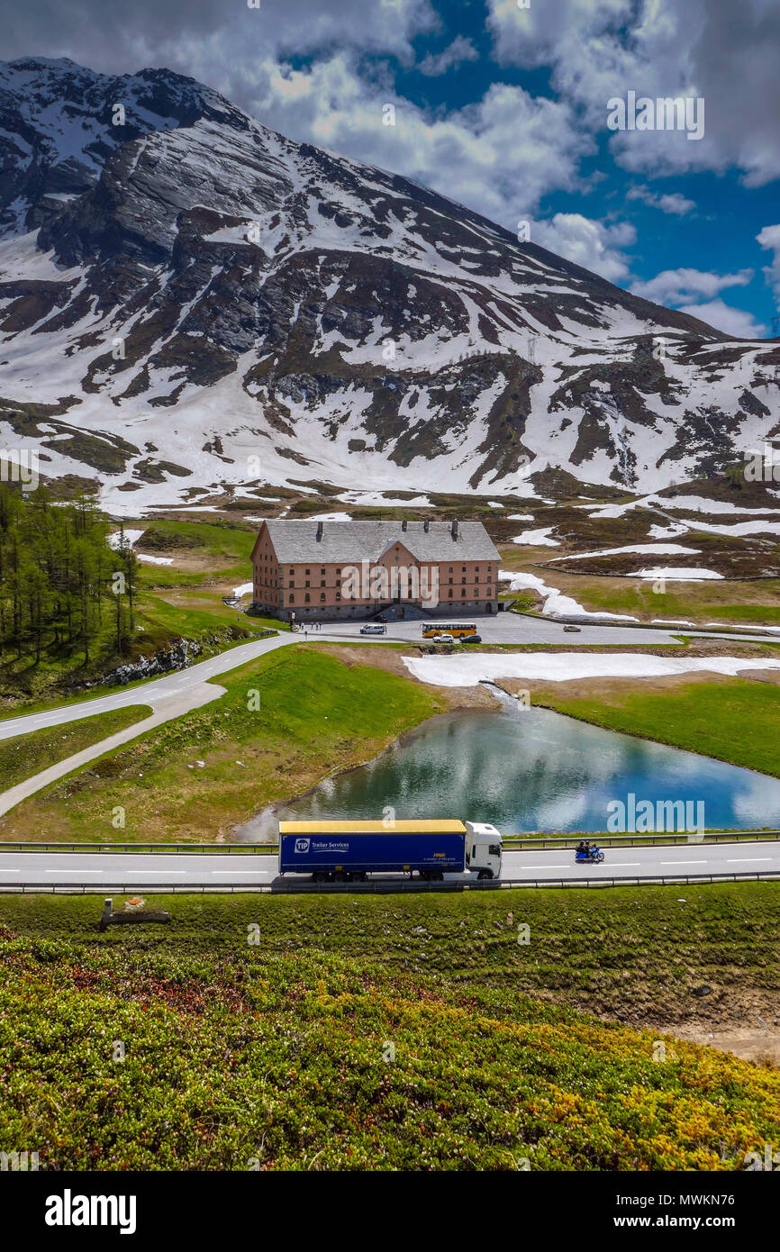 Simplon Hospitz con il carrello, giallo bus postale e nevoso meteo in montagna sul Passo del Sempione, tra Svizzera e Italia Foto Stock