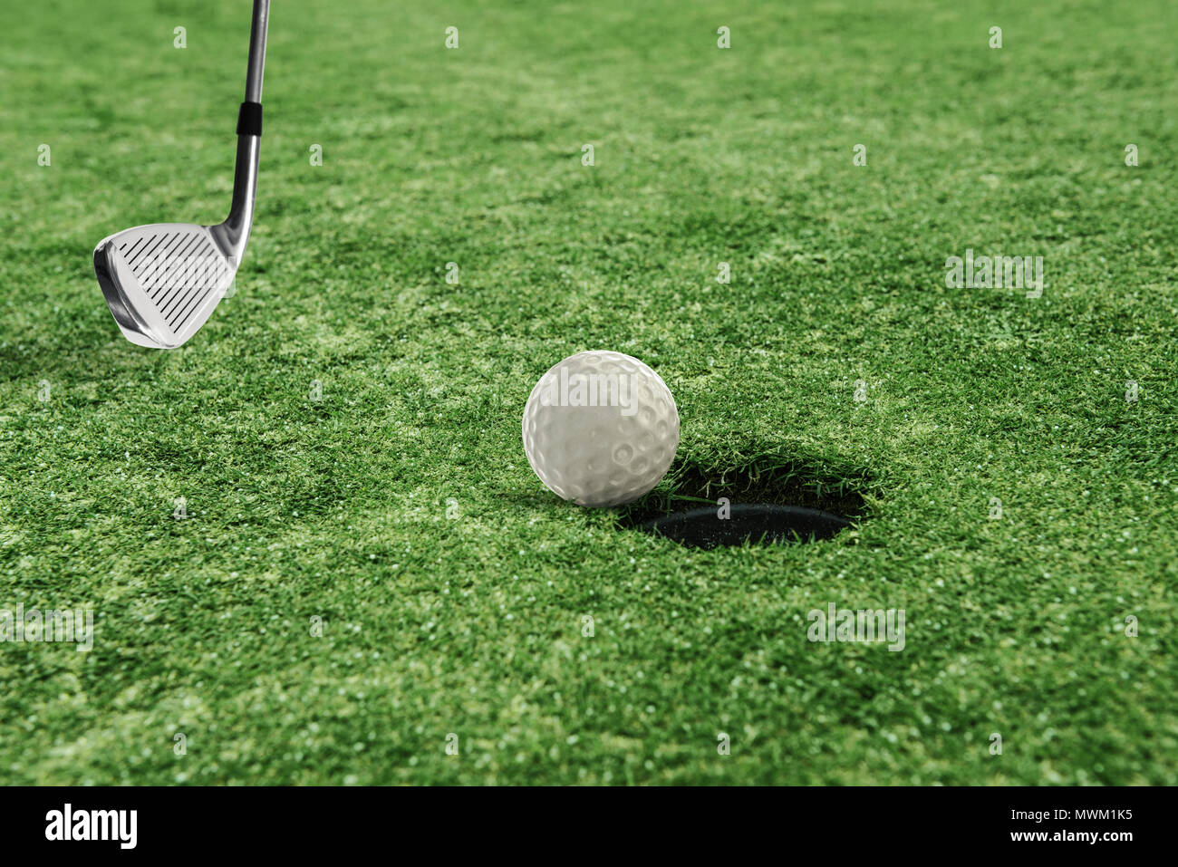 Palla da golf vicino al foro in un campo di erba Foto Stock