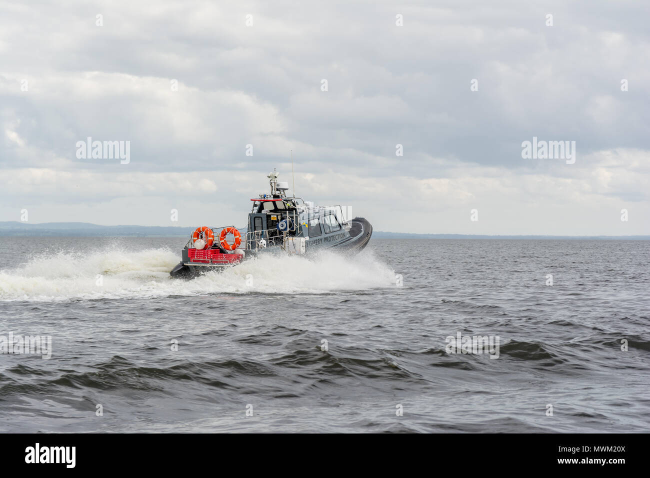 La protezione della pesca nave accelerando attraverso le onde di acqua dolce del Lough Neagh in Irlanda del Nord Foto Stock