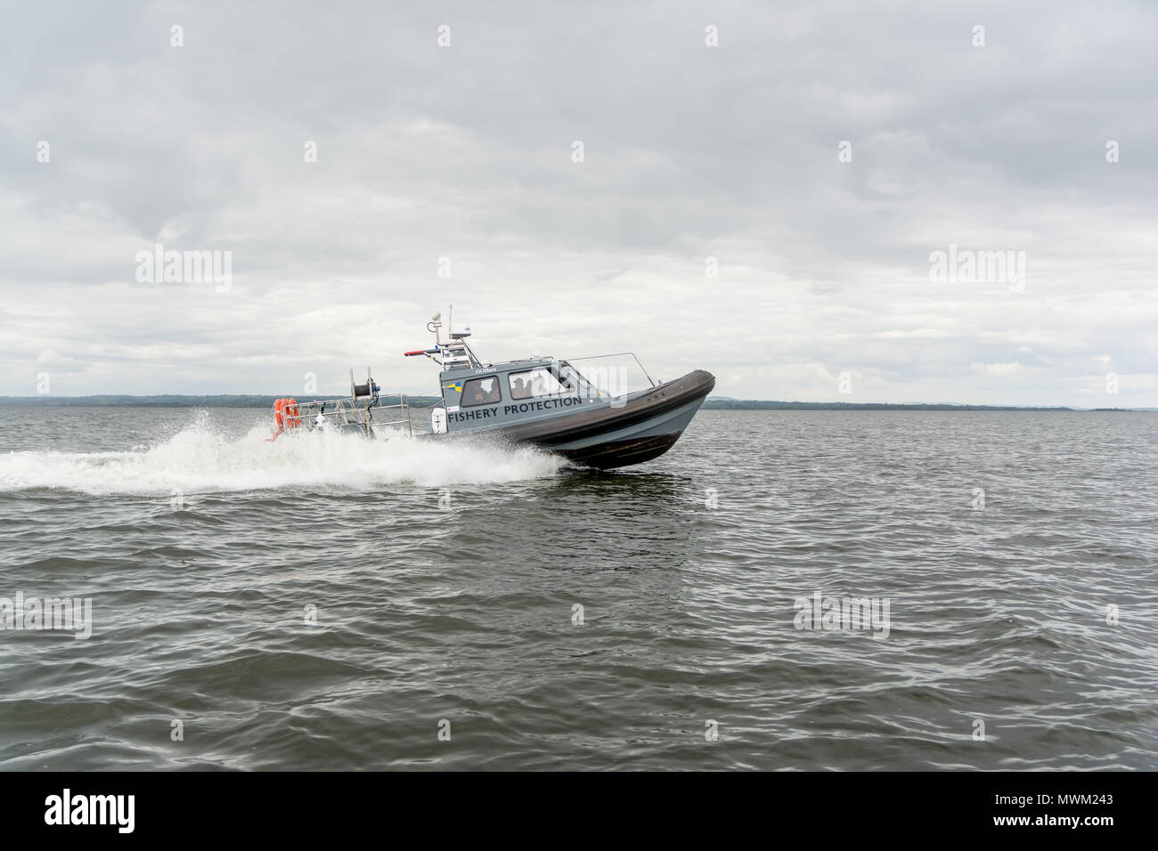 La protezione della pesca nave accelerando attraverso le onde di acqua dolce del Lough Neagh in Irlanda del Nord Foto Stock