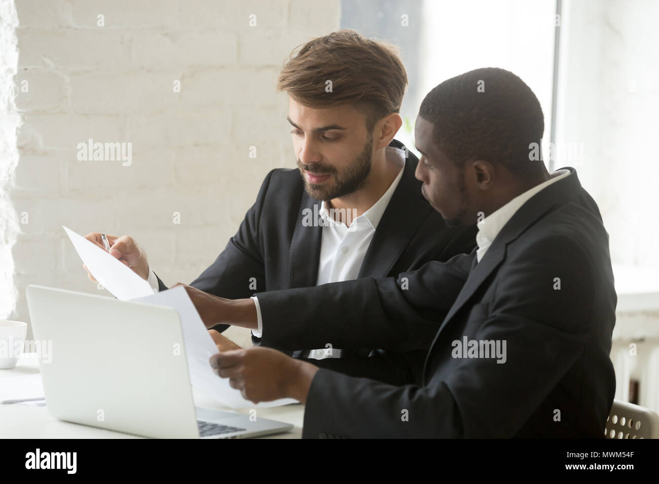 Gli imprenditori seri a discutere di società di documenti cartacei in ufficio Foto Stock