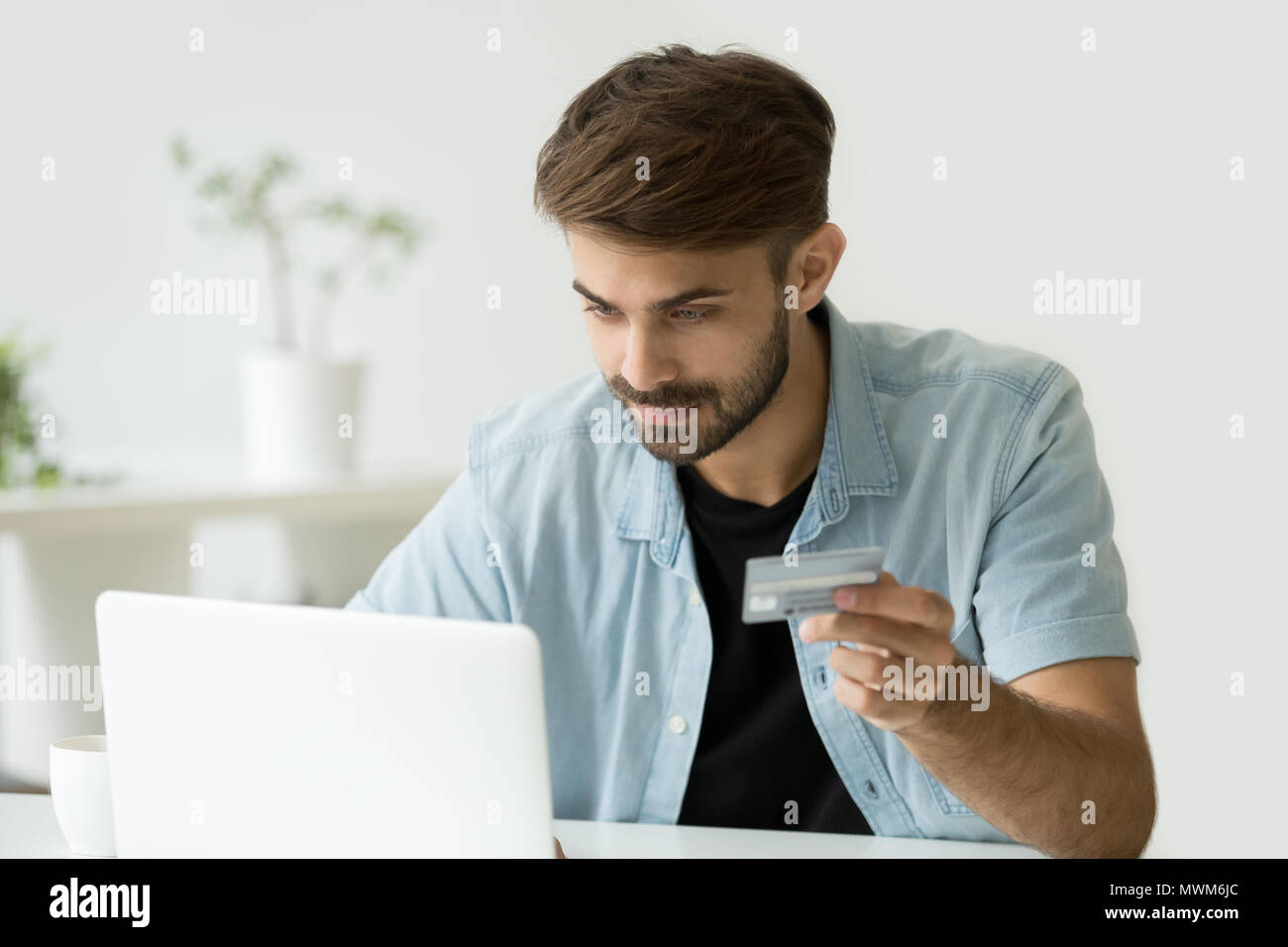 Uomo felice shopping online immettendo le informazioni della carta di credito Foto Stock