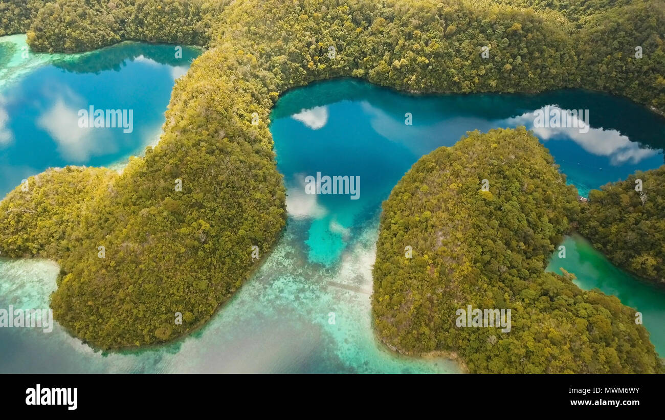Vista aerea: spiaggia, isola tropicale, Baia Mare e laguna, Siargao. Paesaggio tropicale hill, nuvole e montagne rocce con la foresta pluviale. Acque azzurre della laguna. Paesaggio Shore Bay. Concetto di viaggio. Foto Stock