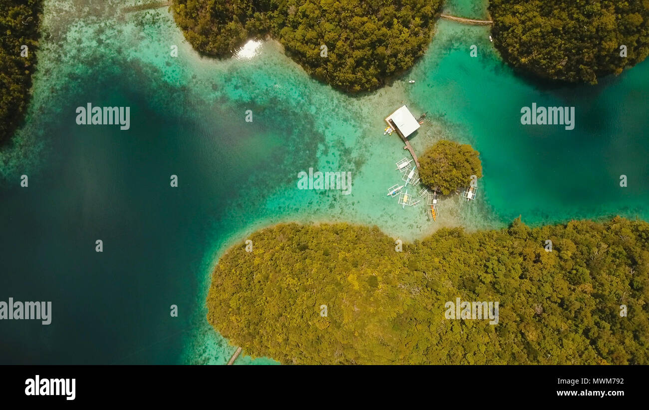 Vista aerea: spiaggia, isola tropicale, Baia Mare e laguna, Siargao. Paesaggio tropicale hill, nuvole e montagne rocce con la foresta pluviale. Acque azzurre della laguna. Paesaggio Shore Bay. Concetto di viaggio. Foto Stock