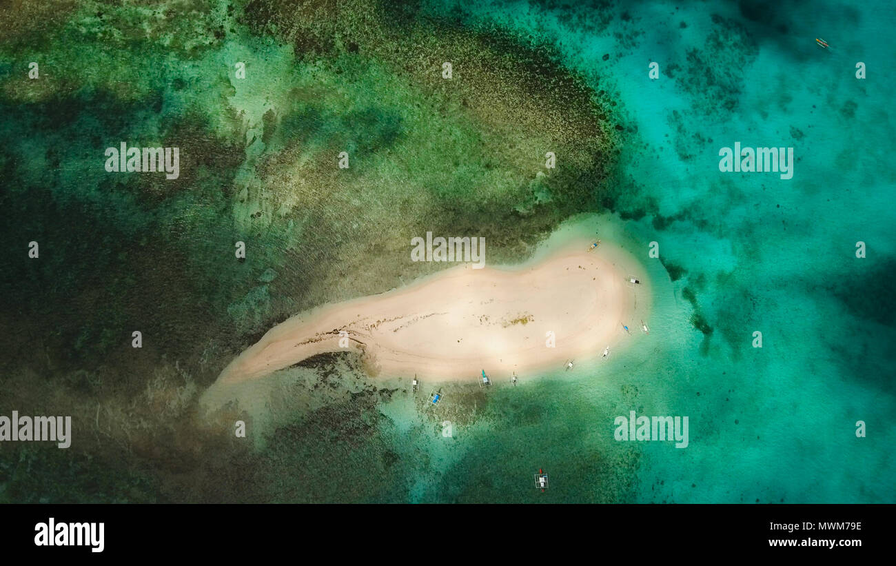 Vista aerea di bella sabbia isola tropicale con spiaggia di sabbia bianca e turisti. La sabbia bianca isola. Seascape: oceano e bellissima spiaggia paradiso. Filippine, Siargao. Concetto di viaggio. Foto Stock