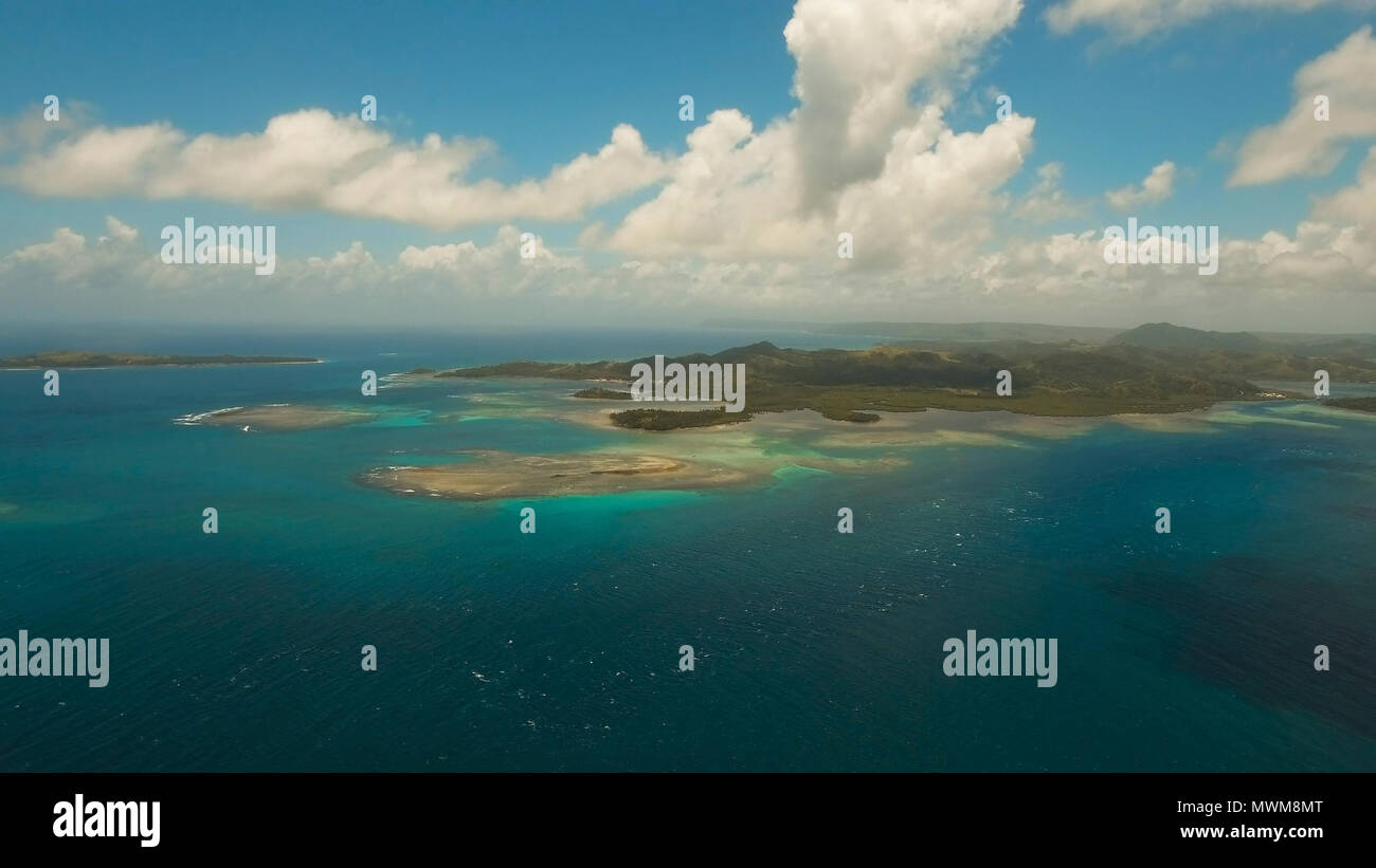 Vista aerea: spiaggia, isola tropicale, Baia Mare e laguna, Siargao. Paesaggio tropicale hill, nuvole e montagne rocce con la foresta pluviale. Acque azzurre della laguna. Paesaggio Shore Bay. Video dell'antenna.Seascape. Foto Stock