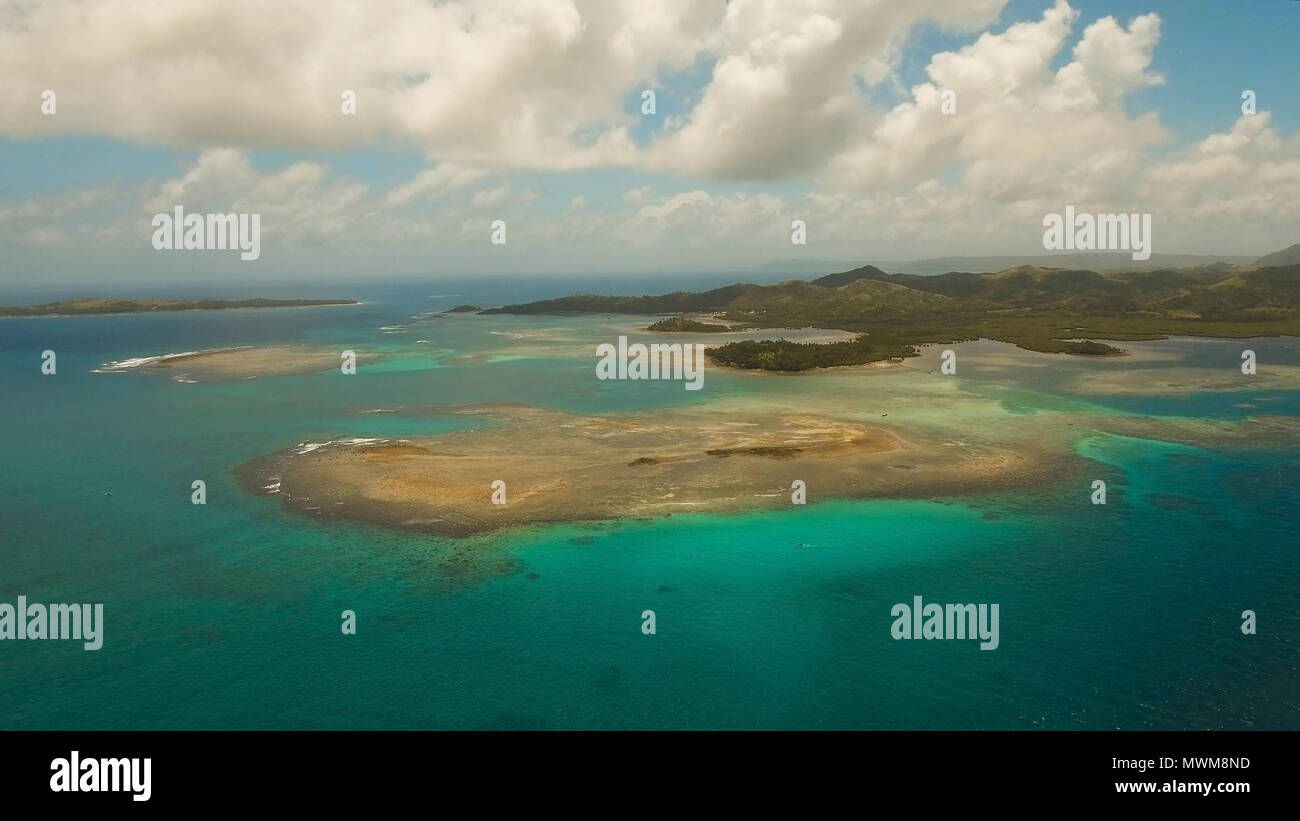 Vista aerea: spiaggia, isola tropicale, Baia Mare e laguna, Siargao. Paesaggio tropicale hill, nuvole e montagne rocce con la foresta pluviale. Acque azzurre della laguna. Paesaggio Shore Bay. Video dell'antenna.Seascape. Foto Stock