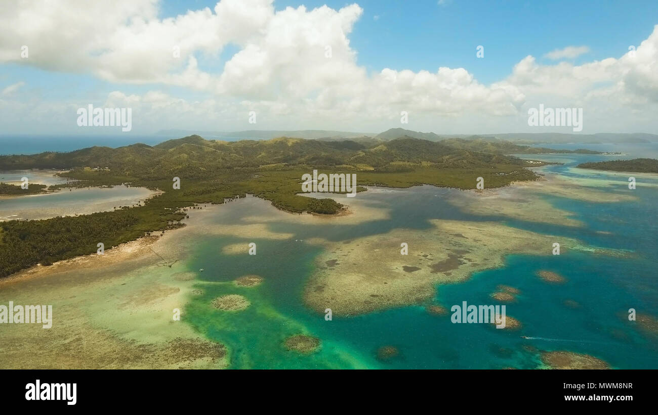 Vista aerea: spiaggia, isola tropicale, Baia Mare e laguna, Siargao. Paesaggio tropicale hill, nuvole e montagne rocce con la foresta pluviale. Acque azzurre della laguna. Paesaggio Shore Bay. Video dell'antenna.Seascape. Foto Stock