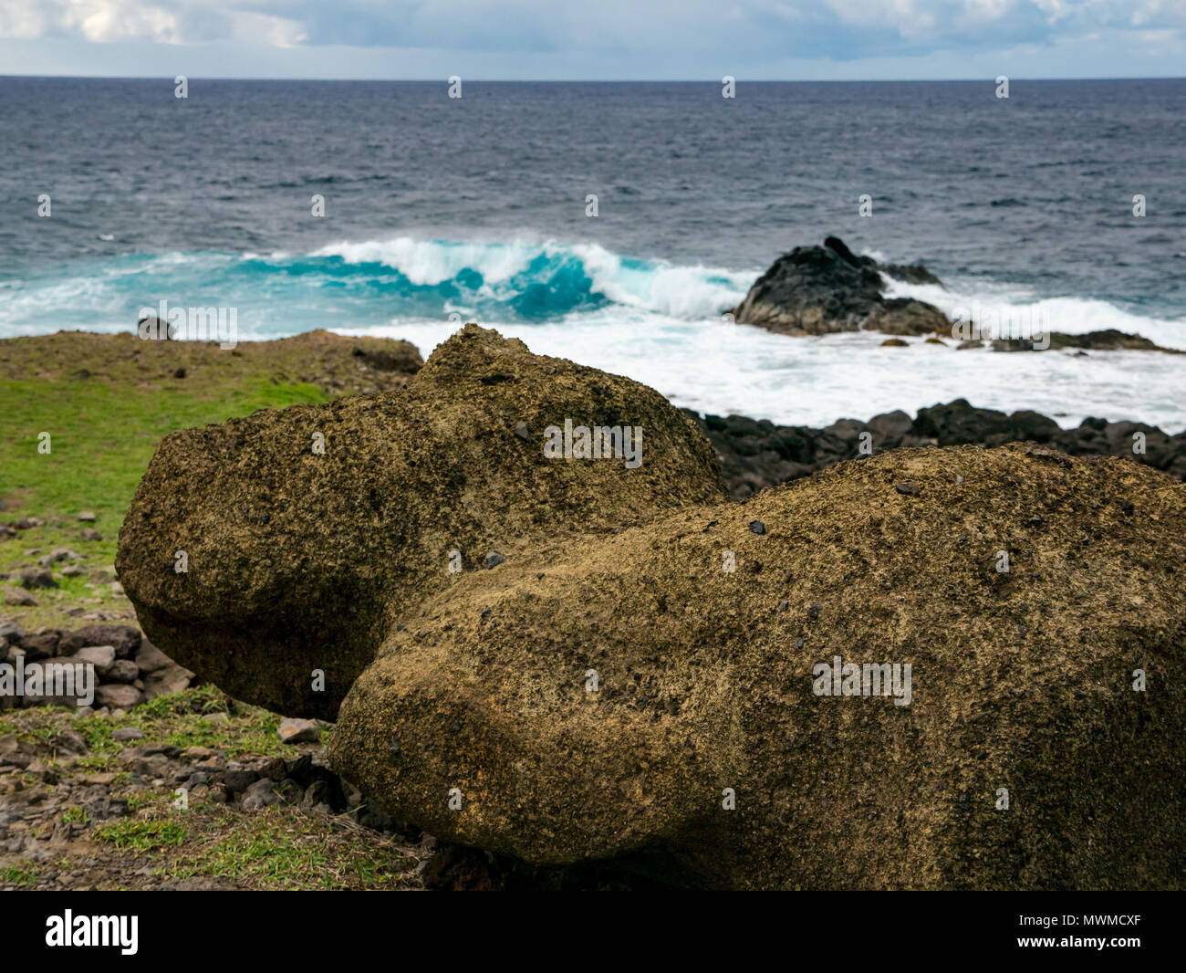 Close up è crollato ancestrale di pietra vulcanica Moai figura accanto alla fascia costiera sull'Oceano Pacifico, Akahanga, Isola di Pasqua, Rapa Nui, Cile Foto Stock