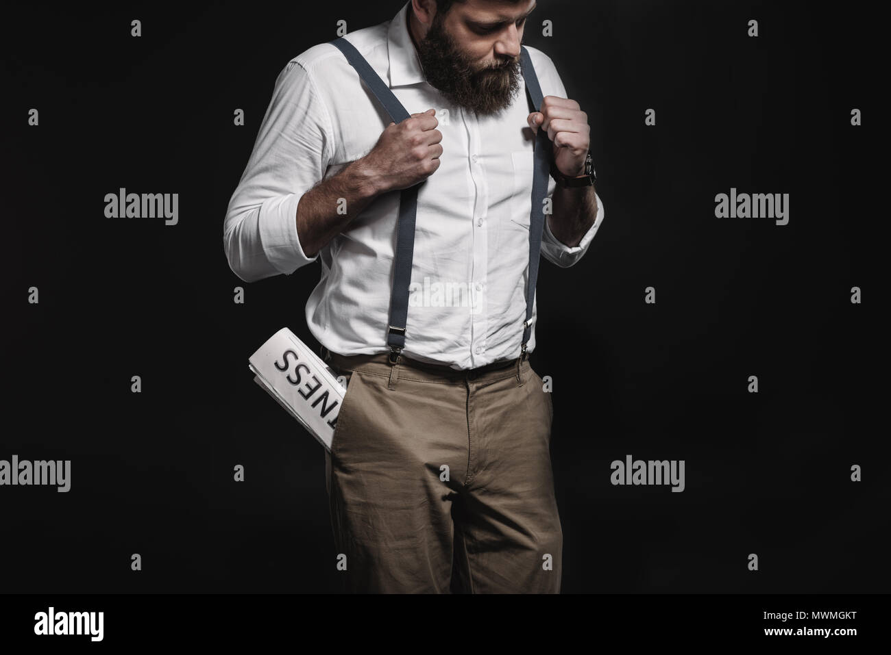 Elegante Uomo in camicia bianca e bretelle in piedi con il business  quotidiano in tasca isolato su nero Foto stock - Alamy