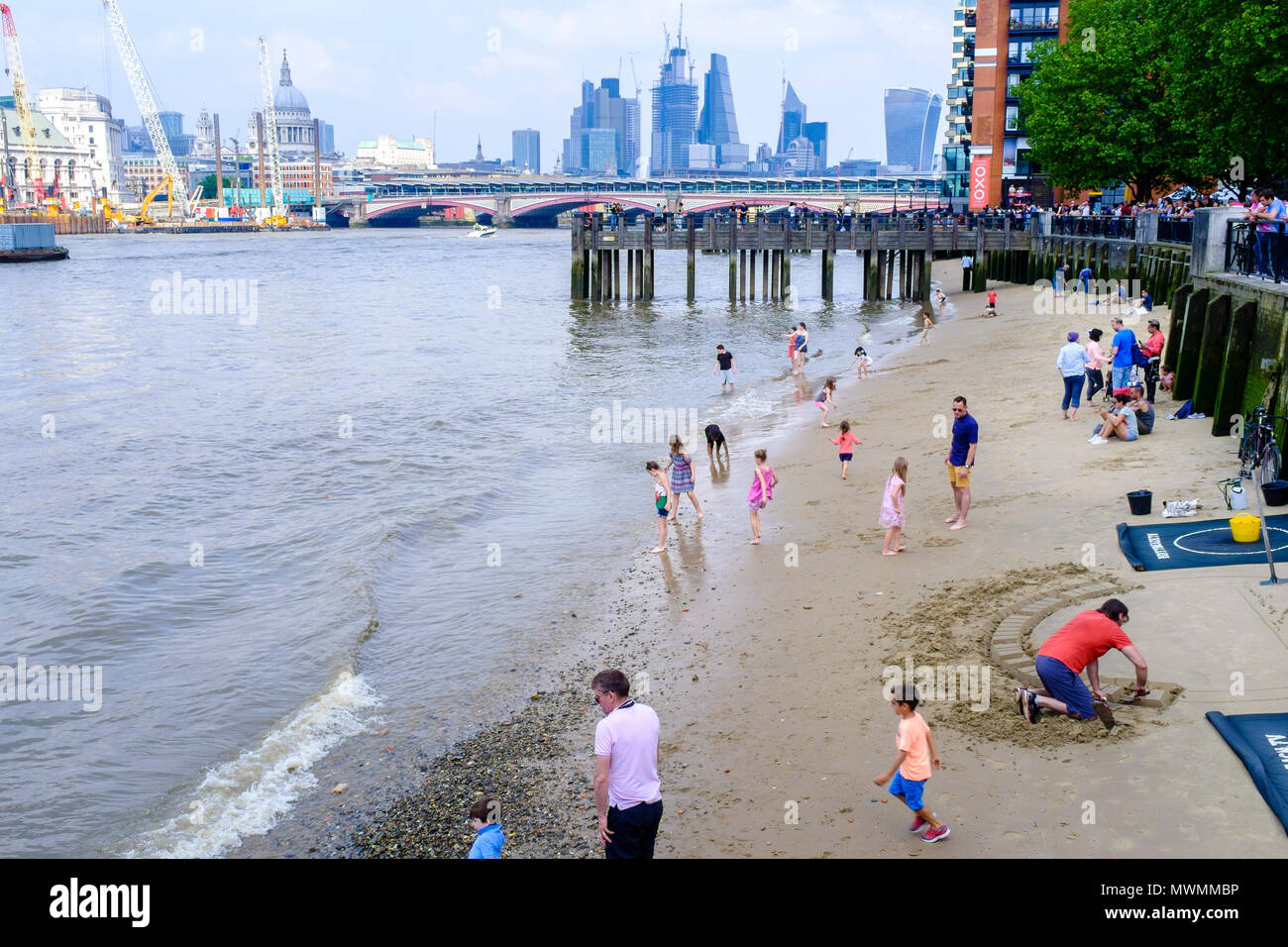 Le persone che si godono la spiaggia di sabbia di fiume Tamigi foreshore con la bassa marea. Foto Stock