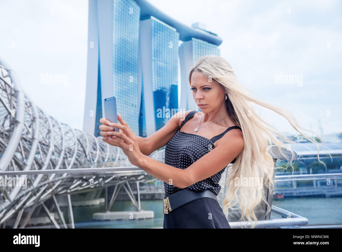 Slim giovane donna bionda ragazzina prende selfie foto fotografie nei pressi di ga Foto Stock