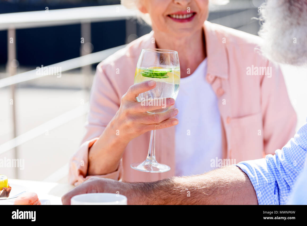 Ritagliato shot di sorridere senior donna drink tenendo a portata di mano Foto Stock