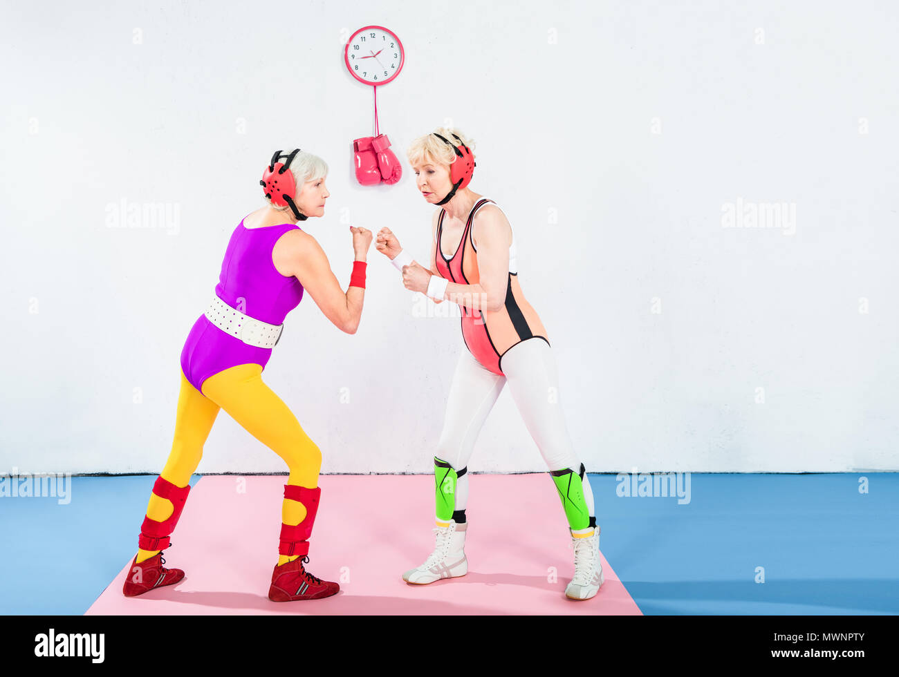 Vista laterale del senior lottatori femminili nella protezione della testa che combattono insieme Foto Stock