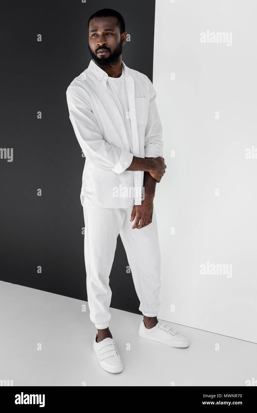 Bello stile americano africano uomo in vestiti di bianco che guarda lontano  Foto stock - Alamy