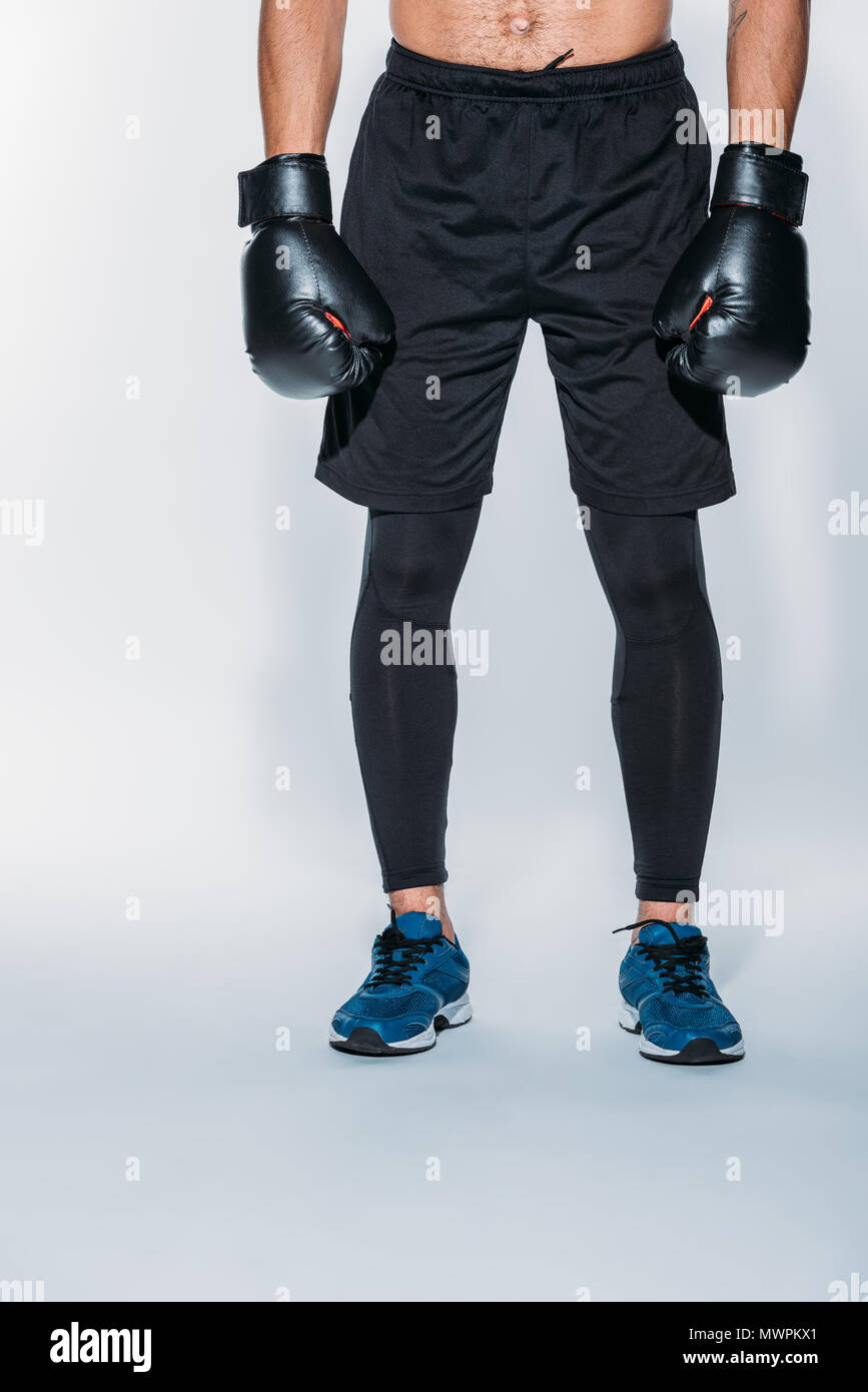 Immagine ritagliata del boxer in sport pantaloncini e guanti Foto Stock