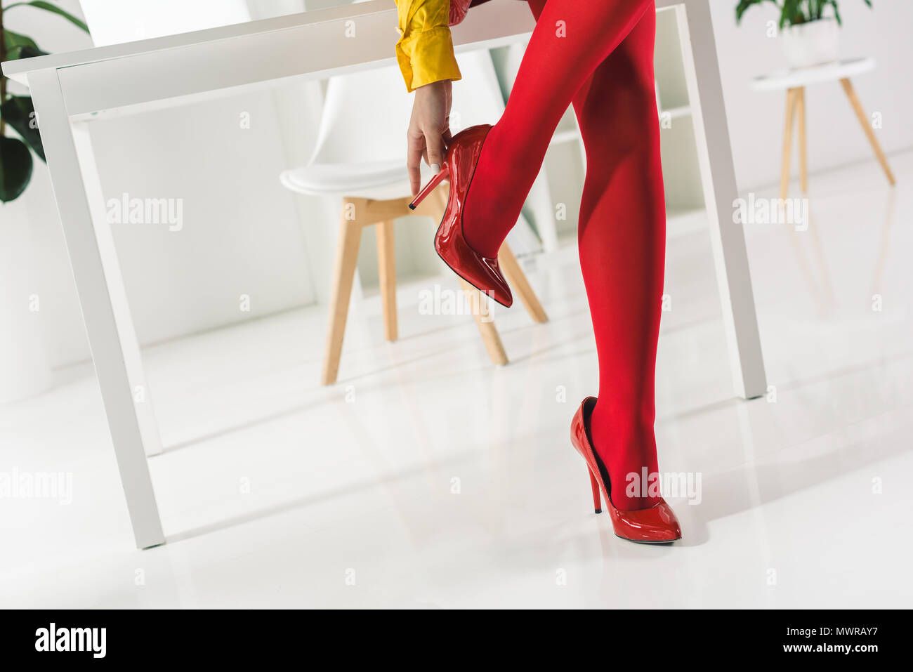 Vista ritagliata della donna elegante in rosso collant e tacchi Foto Stock