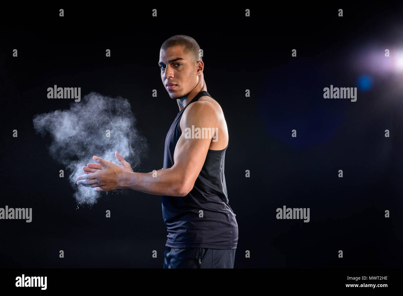 African American sportsman battendo le mani con talco su nero Foto Stock
