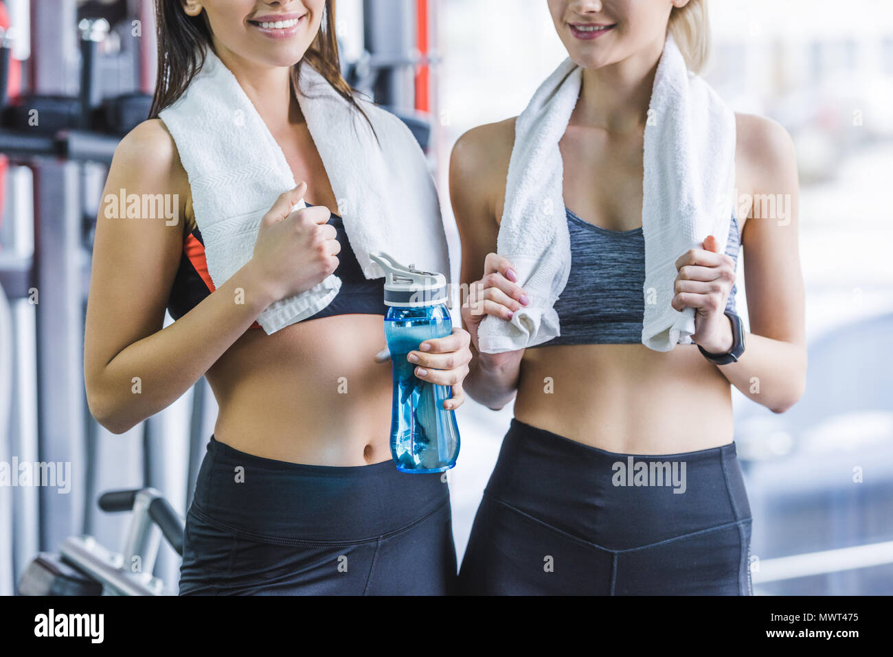Ritagliato colpo di donne sportive con asciugamani rilassante dopo la formazione presso la palestra Foto Stock