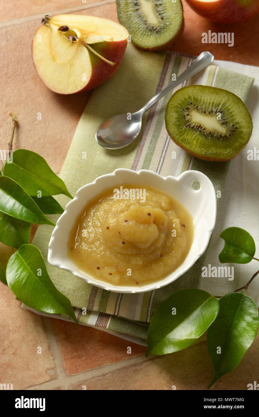 Kiwi e mousse di apple con frutta intorno - porzione nella ciotola bianco - primo piano Foto Stock