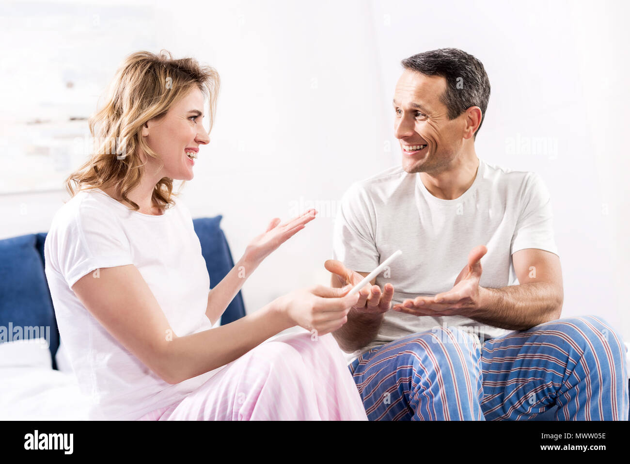 Ritratto di felice moglie con test di gravidanza e il marito a casa Foto Stock