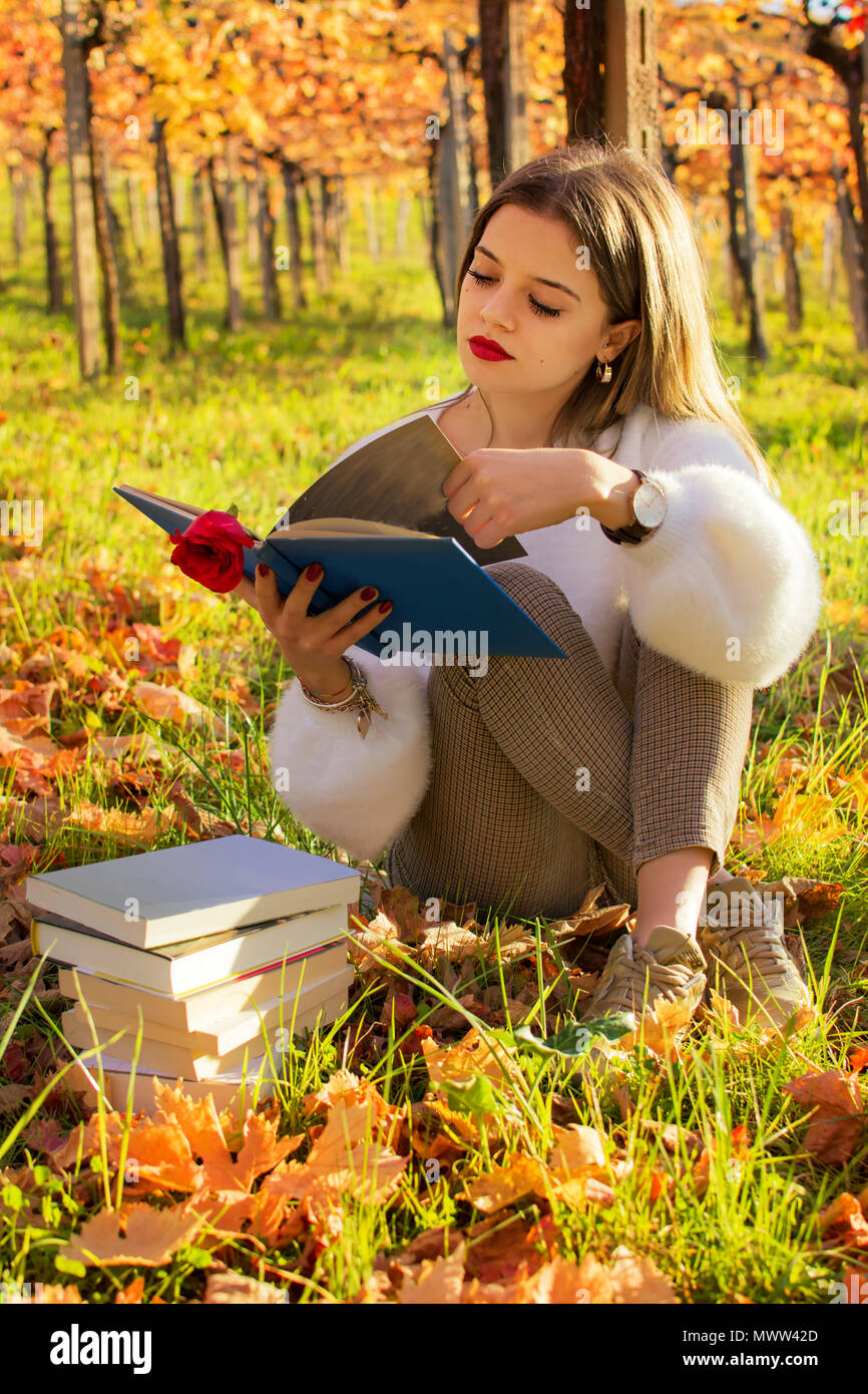 Ragazza la lettura di un libro seduti nella natura Foto Stock