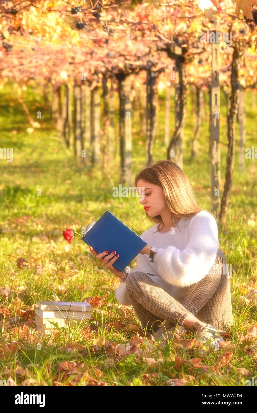 Ragazza la lettura di un libro seduti nella natura Foto Stock
