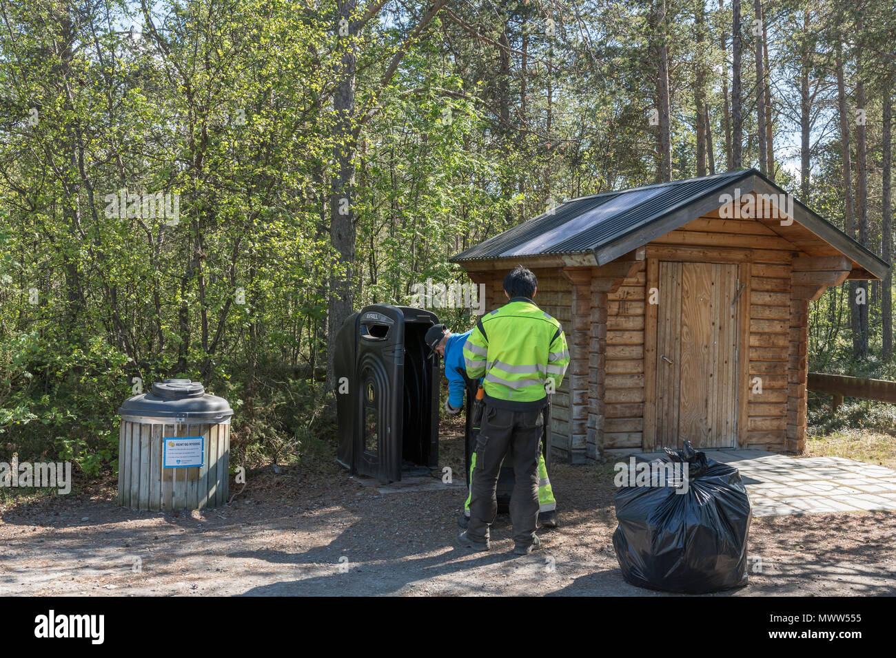 Due uomini lo svuotamento di spazzatura da una roulotte posto nel nord della Norvegia, Finnmark Foto Stock