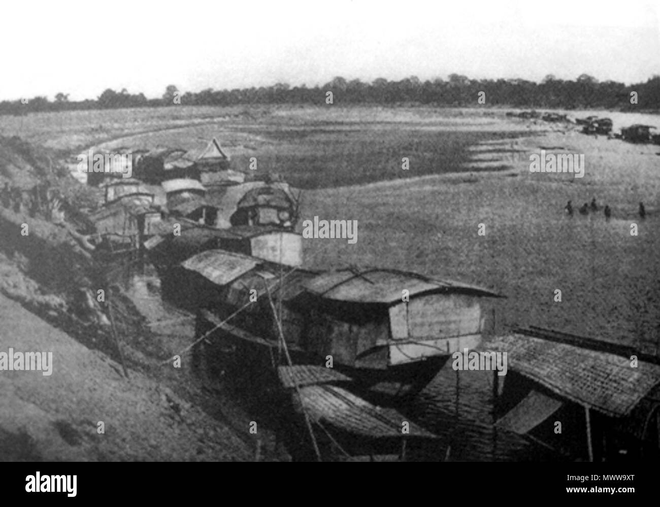 . ไทย: ภาพถ่ายวิถีชีวิตริมน้ำของชาวท่าเสาและคุ้งตะเภา ผลงานของ มร.คาร์ล โดห์ริง (KARL DOEHRING) สถาปนิกเยอรมันผู้สมัครเข้ามาทำงานกับการรถไฟสยามในสมัยรัชกาลที่ 5. ภาพนี้เป็นภาพที่ 16 ในหนังสือ ปรากฎข้อความใต้ภาพว่า '...vicino a Tha Sa(o)' สันนิษฐานว่าภาพนี้ถ่ายจากฝั่งแม่น้ำน่านทิศตะวันออกอันเป็นที่ตั้งของบ้านท่าเสา ฝั่งตรงข้ามคือแถบย่านตำบลคุ้งตะเภา ถ่ายที่: ริมแม่น้ำน่าน ท่าเสา ตรงข้ามกับตำบลคุ้งตะเภา อำเภอบางโพ แขวงเมืองพิชัย ในสมัยรัชกาลที่ 5. ภาพจาก- Karl Doehring. (1920). Il paese e il popolo del Siam. Londra : White Lotus Co Ltd. ISBN 978-9748434872 Inglese: Nan River in Tha Sao & Khung Taph Foto Stock