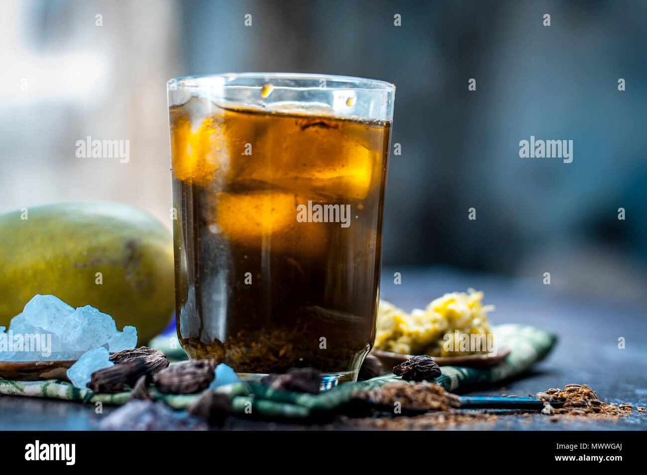 Close up di indiani e famosa asiatica di succo di mango AAM panna in un vetro trasparente con cubetti di ghiaccio, amomi e cardamomi,zucchero,nero sale e jaggery. Foto Stock