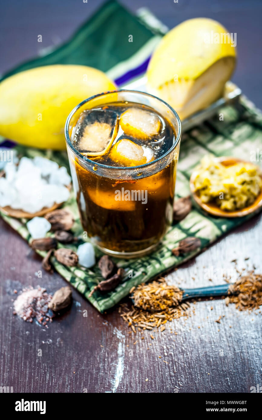 Close up di indiani e famosa asiatica di succo di mango AAM panna in un vetro trasparente con cubetti di ghiaccio, amomi e cardamomi,zucchero,nero sale e jaggery. Foto Stock