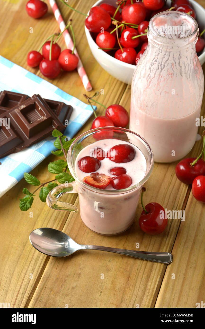 Di yogurt fresco con ciliege rosse nel bicchiere di vetro - primo piano Foto Stock