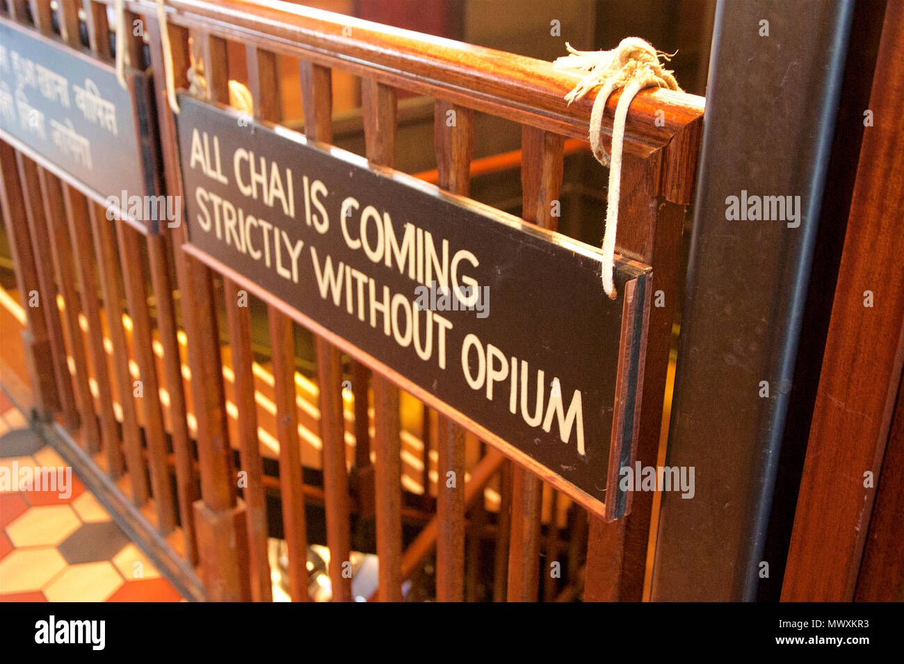 "Tutte le chai è venuta rigorosamente senza oppio' segno appeso da corda fuori da un corrimano in legno interno Dishoom, un ristorante indiano in Shoreditch, Londra Foto Stock