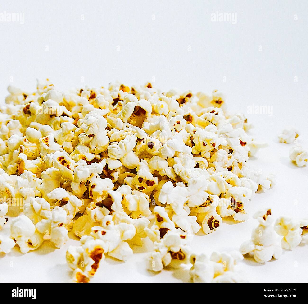 Pop corn su una superficie bianca. Close-up. Immagine di stock. Foto Stock