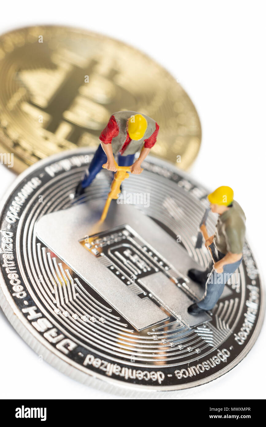 Lavoratori in miniatura Mining Dash Cryptocoin su una superficie bianca Foto Stock