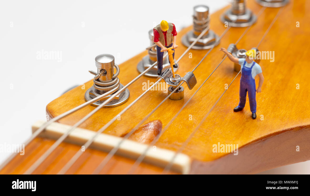 Lavoratori in miniatura che fissa la struttura della stringa di una  chitarra elettrica Foto stock - Alamy