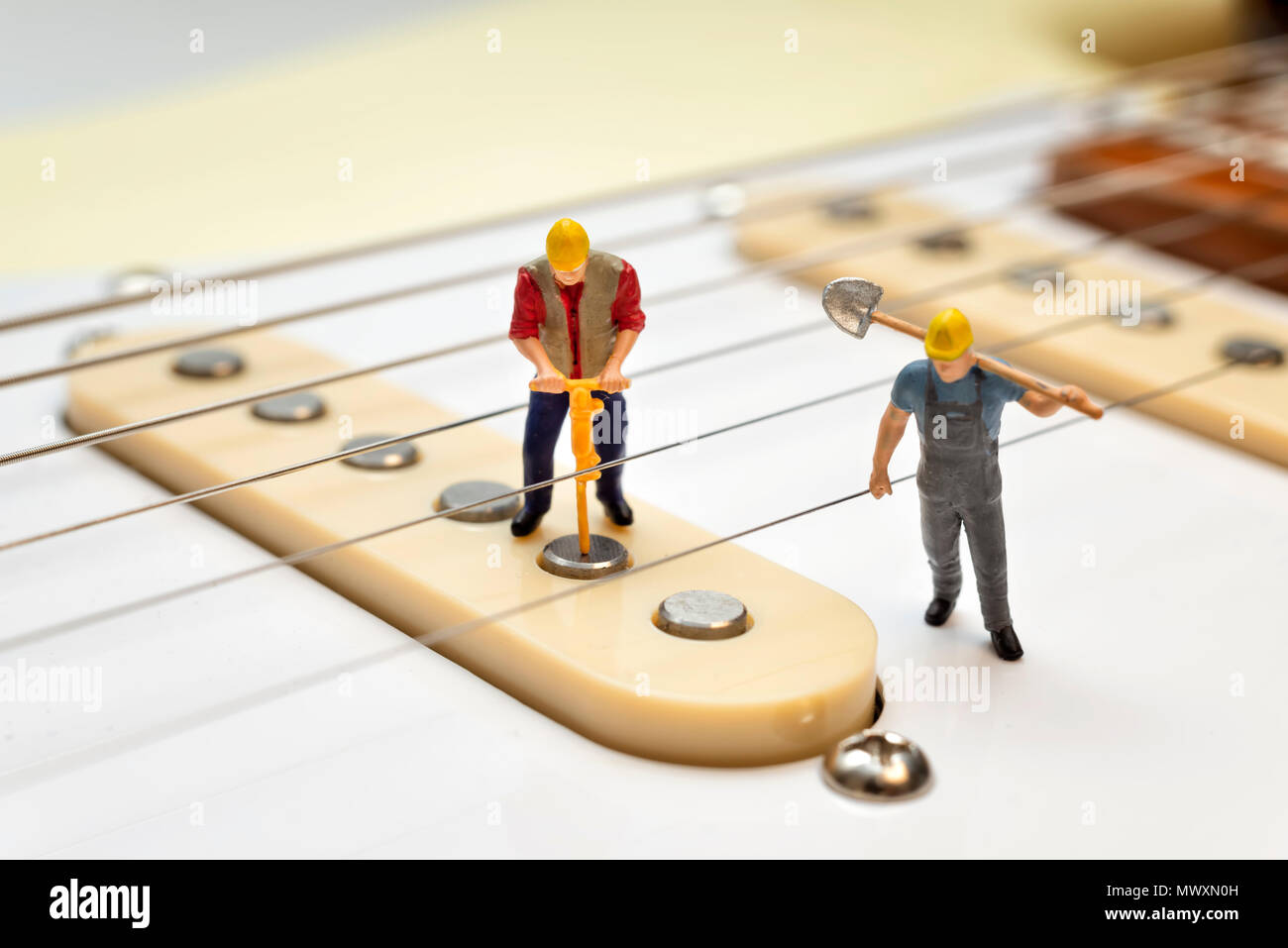 Lavoratori in miniatura che fissa la chitarra elettrica pickup Foto Stock