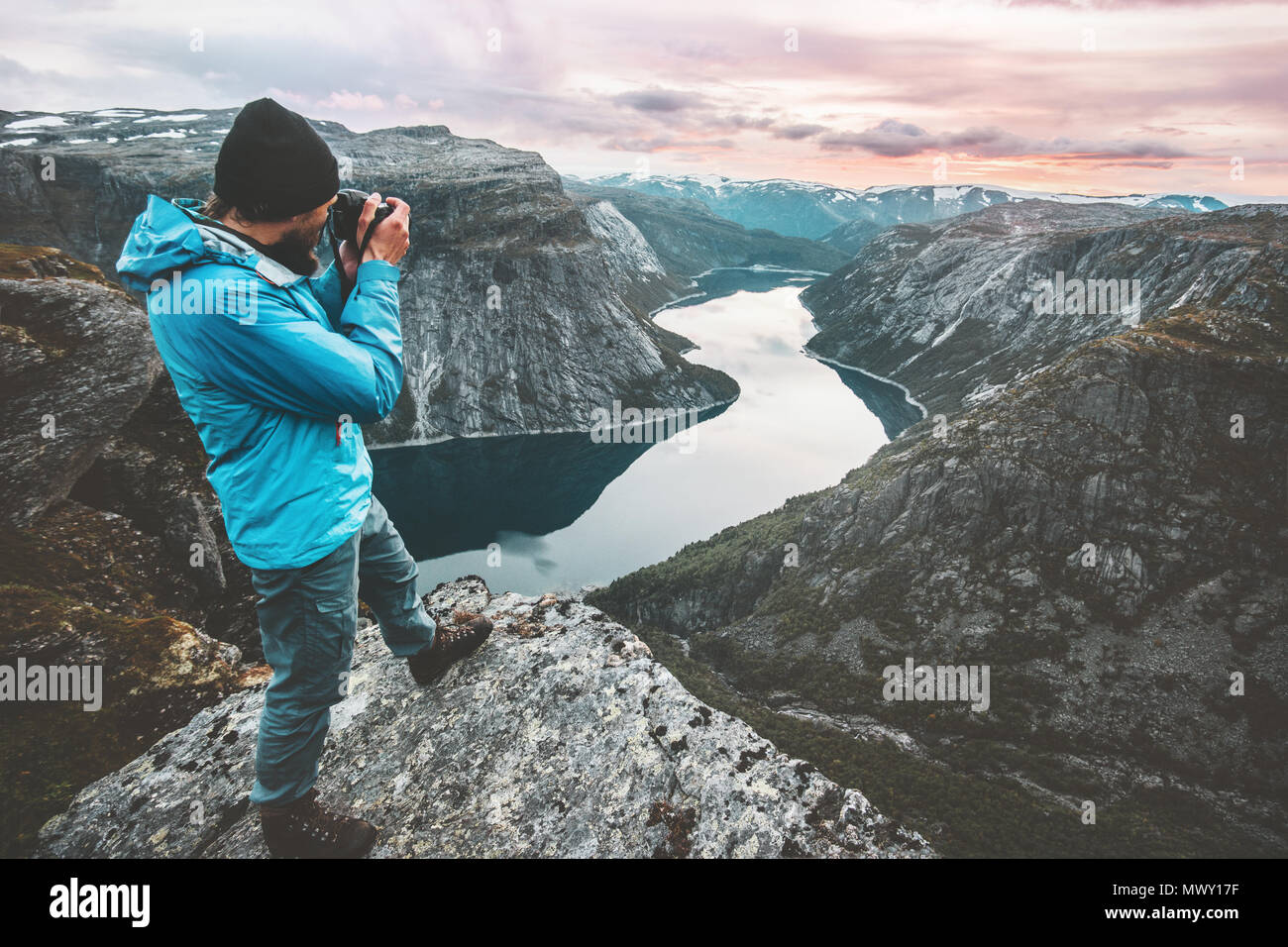 Uomo fotografo di viaggio prendendo foto paesaggio in Norvegia montagne permanente sulla scogliera hobby lifestyle avventura vacanze lago vista aerea Foto Stock
