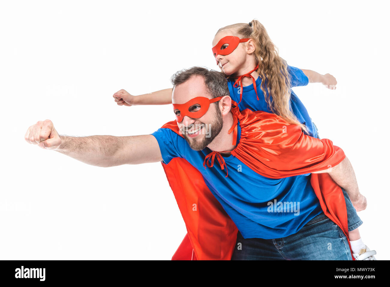 Felice padre e figlia in costumi di supereroi fingendo di volare isolato su bianco Foto Stock