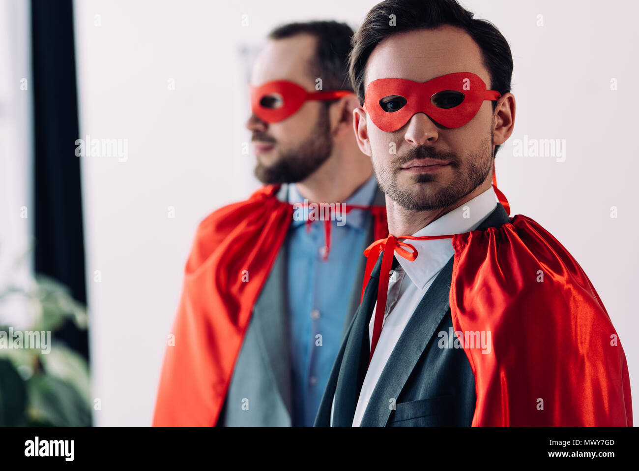 Ritratto di bello super imprenditori in maschere e mantelli in office Foto Stock