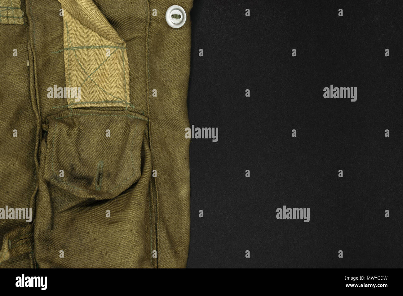 Molto vecchio militare verde borsa per maschera a gas su sfondo nero in superficie con spazio libero Foto Stock